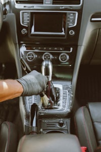 a man in gloves is cleaning the steering wheel of a car